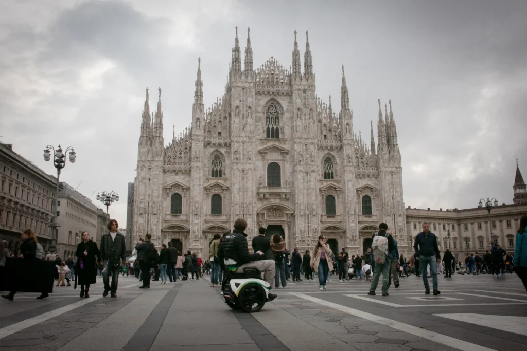 Een persoon in een Genny Zero balansrolstoel op het plein voor de Duomo van Milaan.